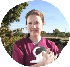 A woman holding a rabbit in a field