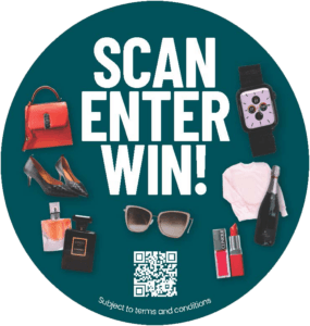 The image features a promotional advertisement titled "SCAN ENTER WIN!" against a dark teal background. It displays a variety of items including a red handbag, black high-heeled shoes, a smartwatch with a playful face, a white T-shirt, sunglasses, a bottle of perfume labeled "COCO CHANEL", a bottle of champagne, and two lipsticks. Centered among these items is a QR code, inviting viewers to scan it for a chance to win these products. The text at the bottom notes that participation is "Subject to terms and conditions," suggesting a contest or giveaway linked to the QR code.