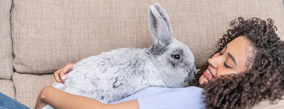 Woman laying down with rabbit on body. Science Selective Food For Life.